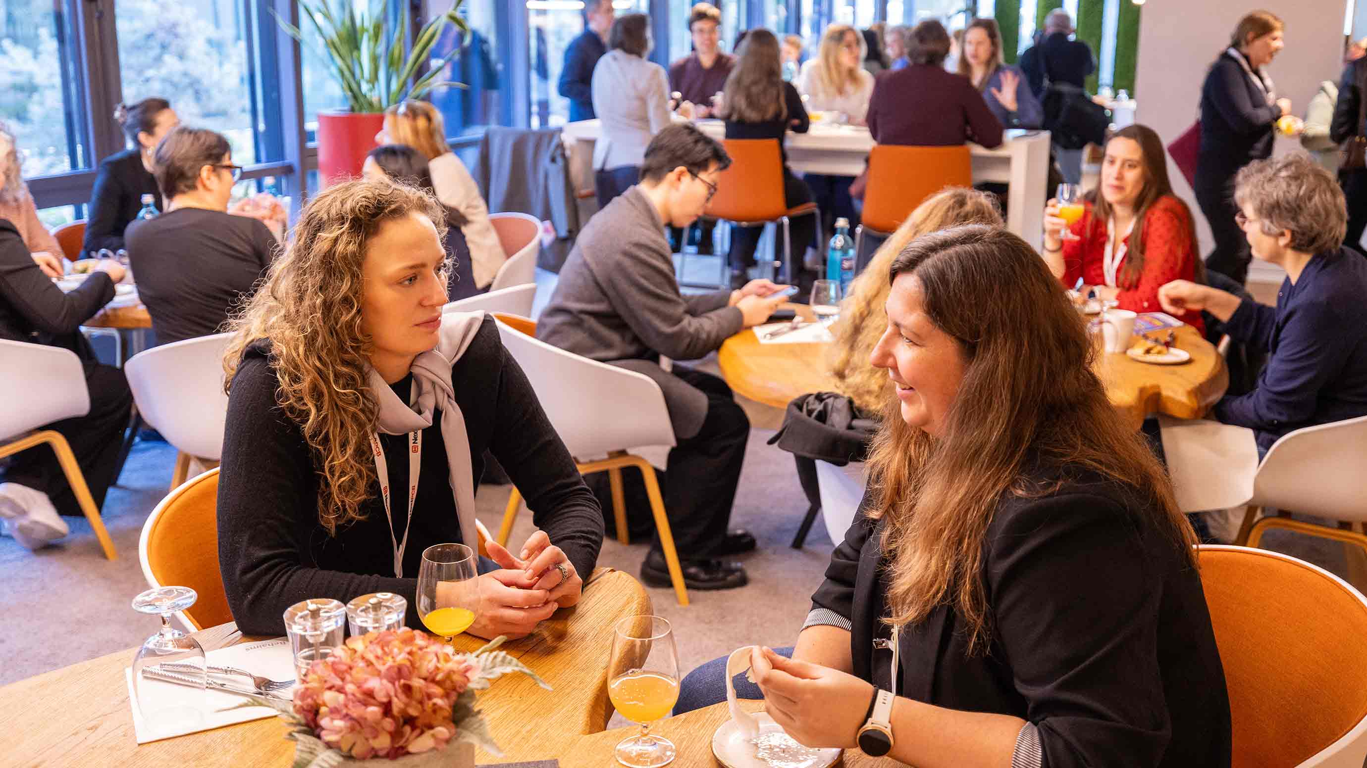 Participants sit at tables and talk over drinks.