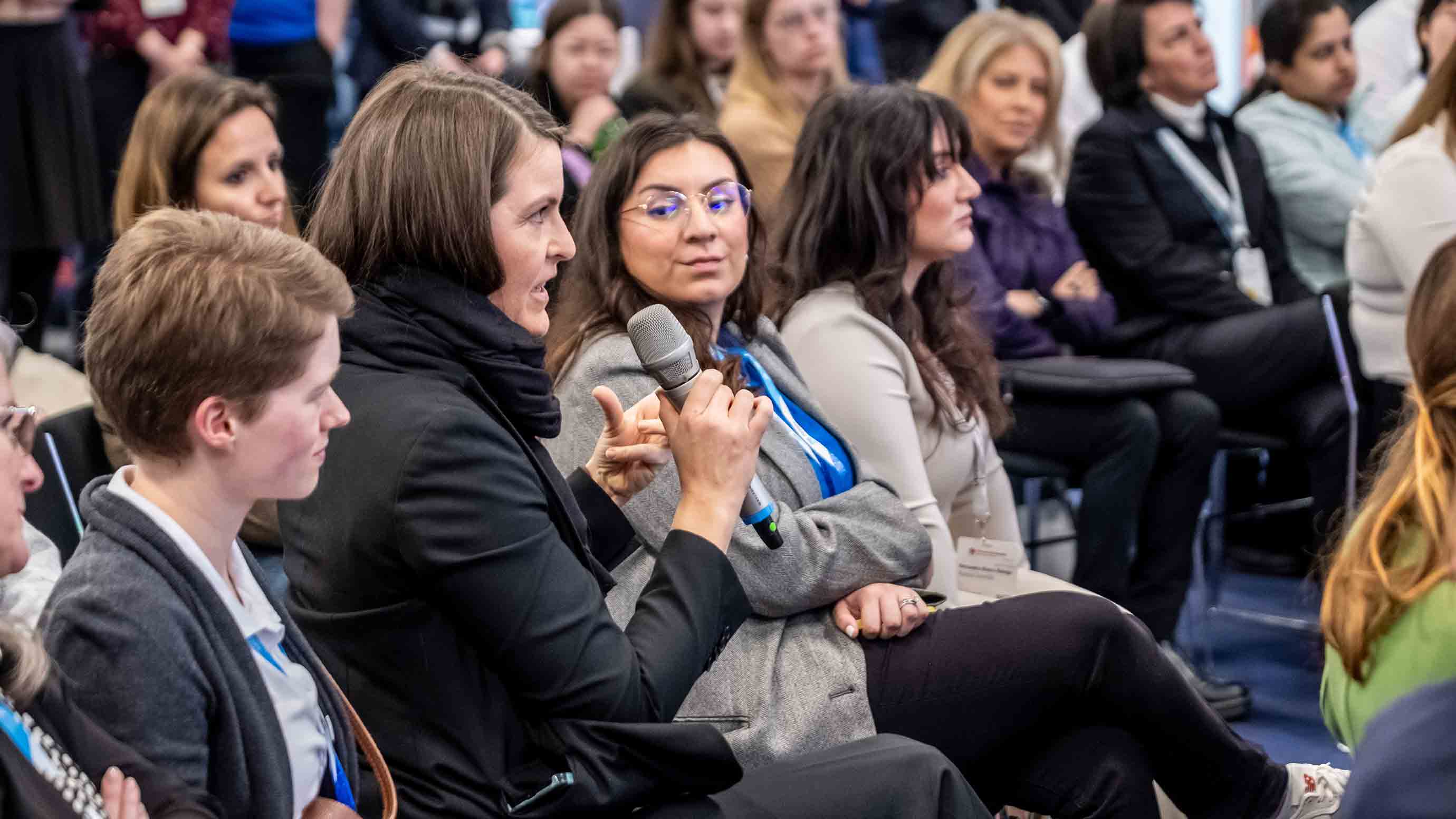 A woman in the audience asks a question to the speaker